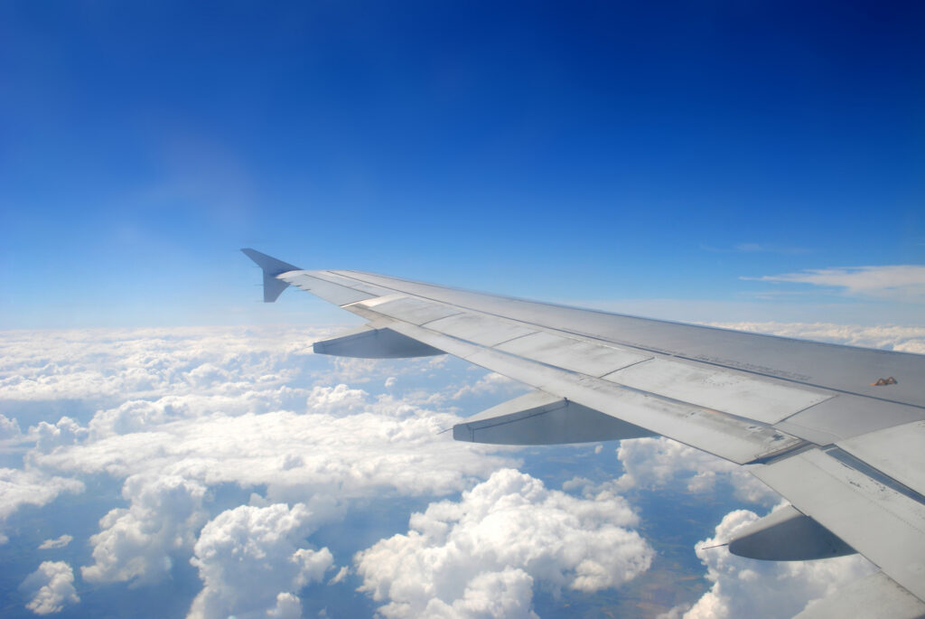 Plane wing flying above the clouds