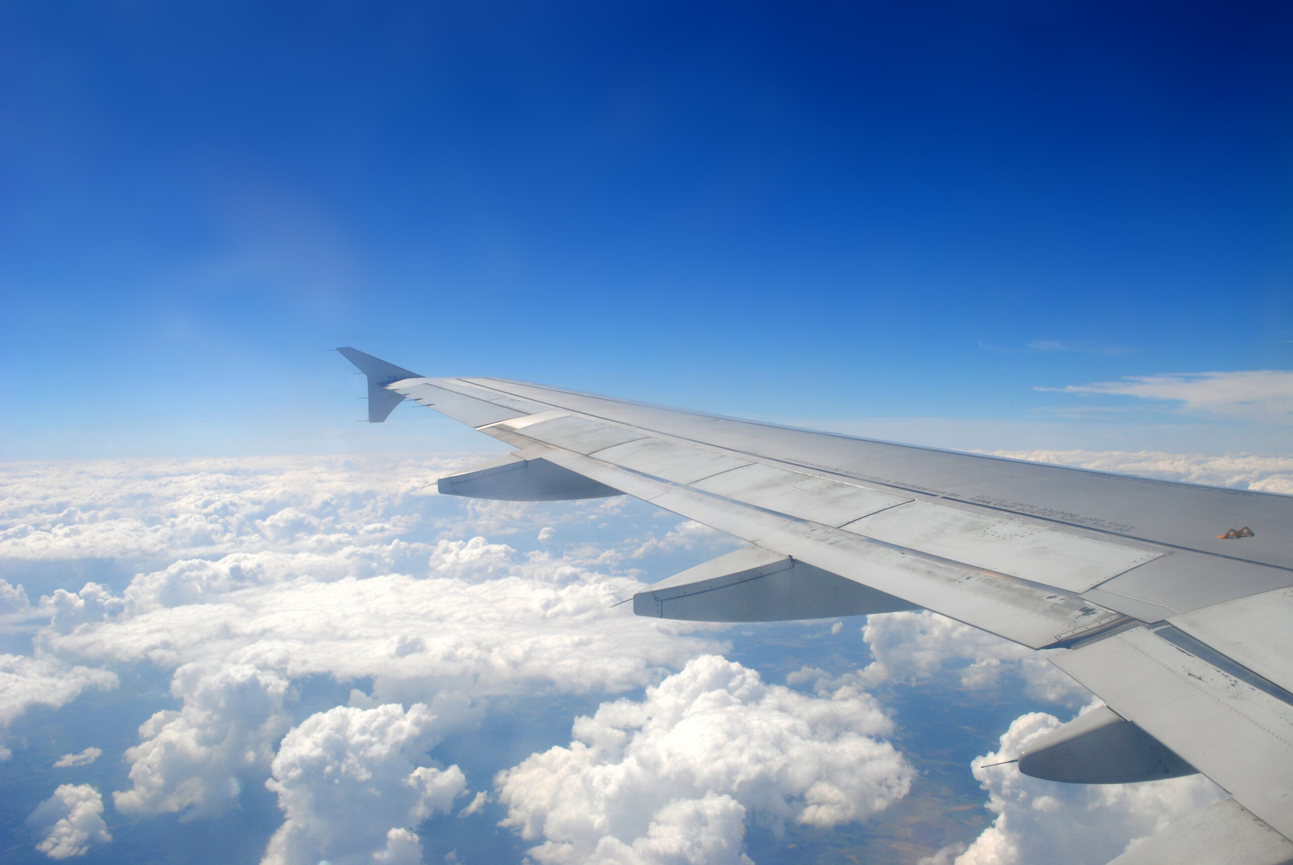 Plane wing flying above the clouds